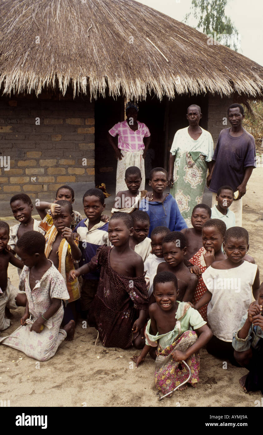 Children and village elders pose together for the camera in a typical village setting - Nkhotakota, Lake Malawi, Malawi Stock Photo