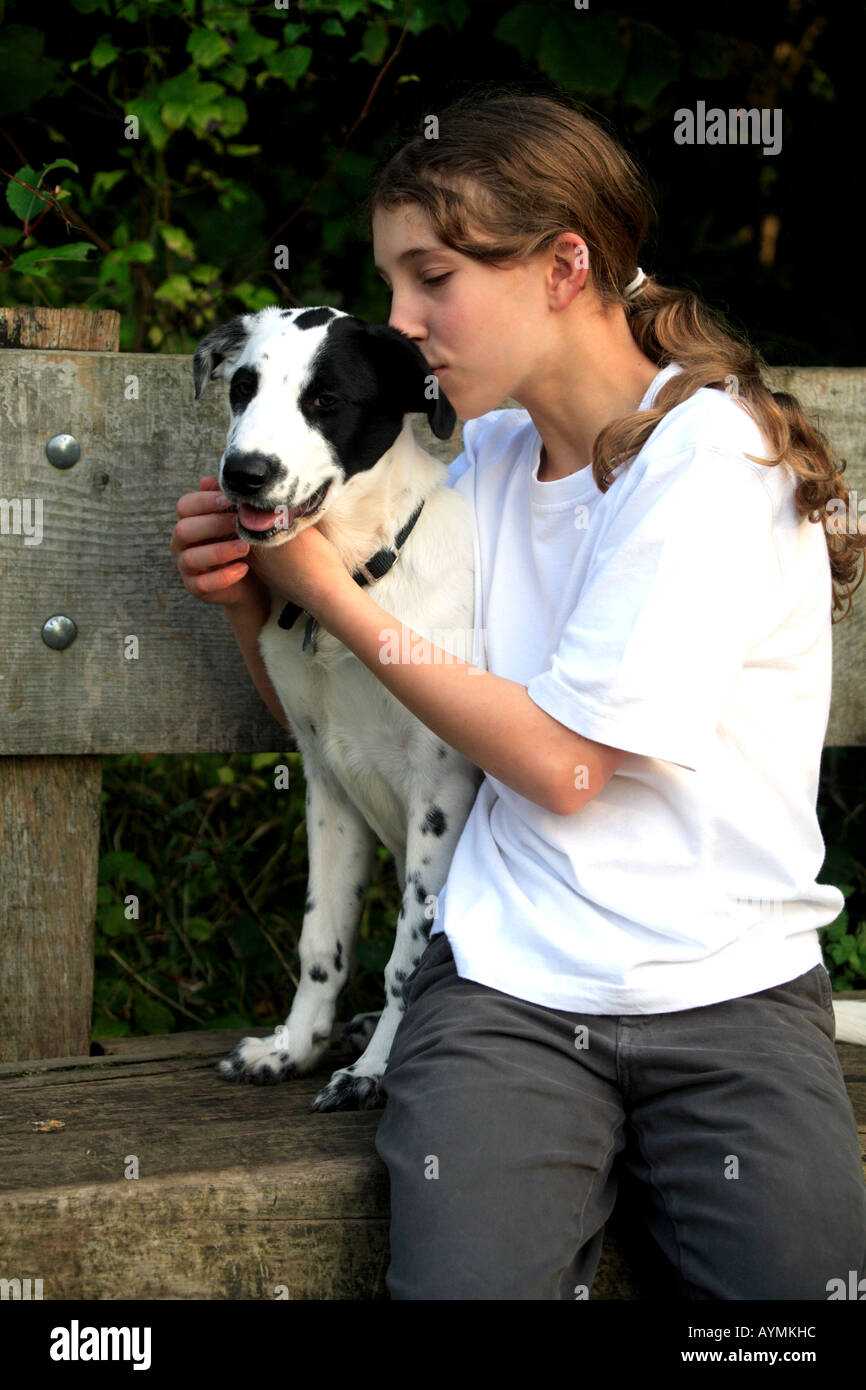 Tara Dalmation dog white black spots eye girl Monty owner sitting bench love cuddle happy kiss Stock Photo