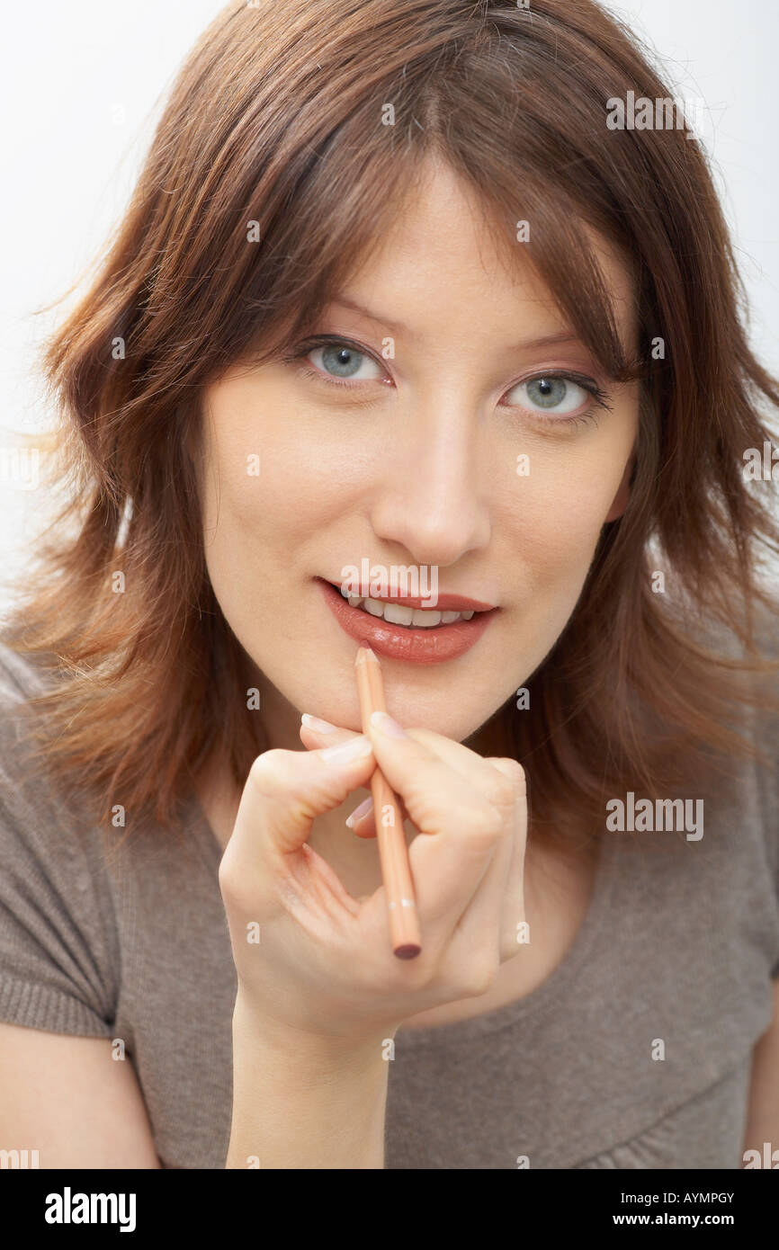 Portrait of a woman applying lip liner Stock Photo