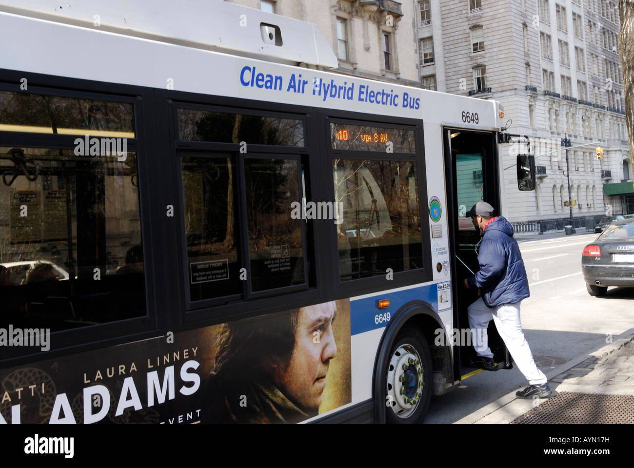 Person boarding a gas electric hybrid bus on its route on the Upper West Side of Manhattan Stock Photo