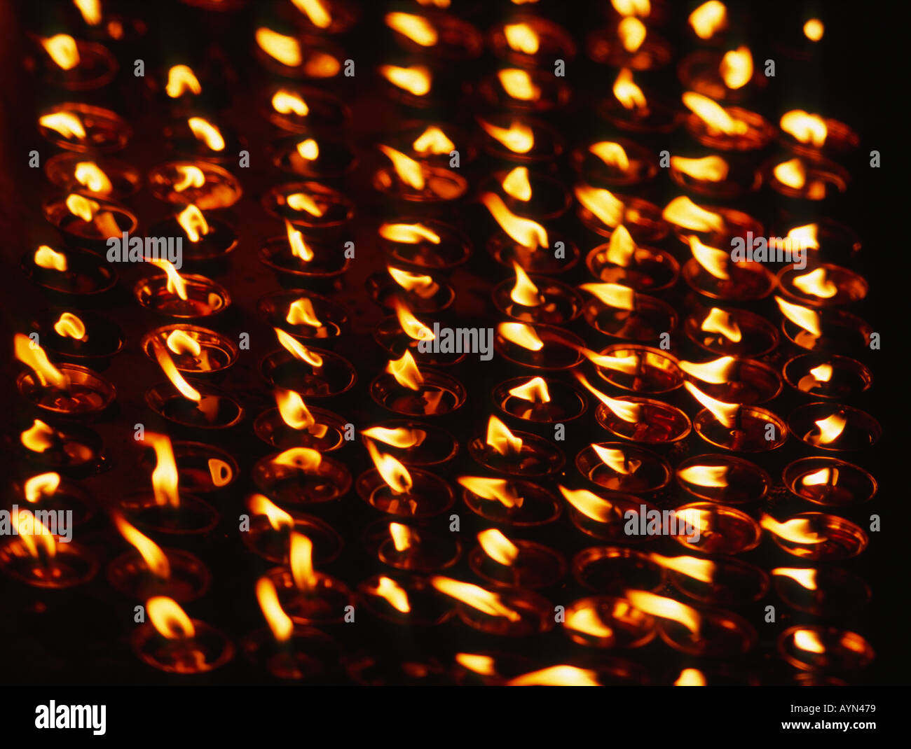 Rows of burning votive candles, oil lamps Stock Photo Alamy