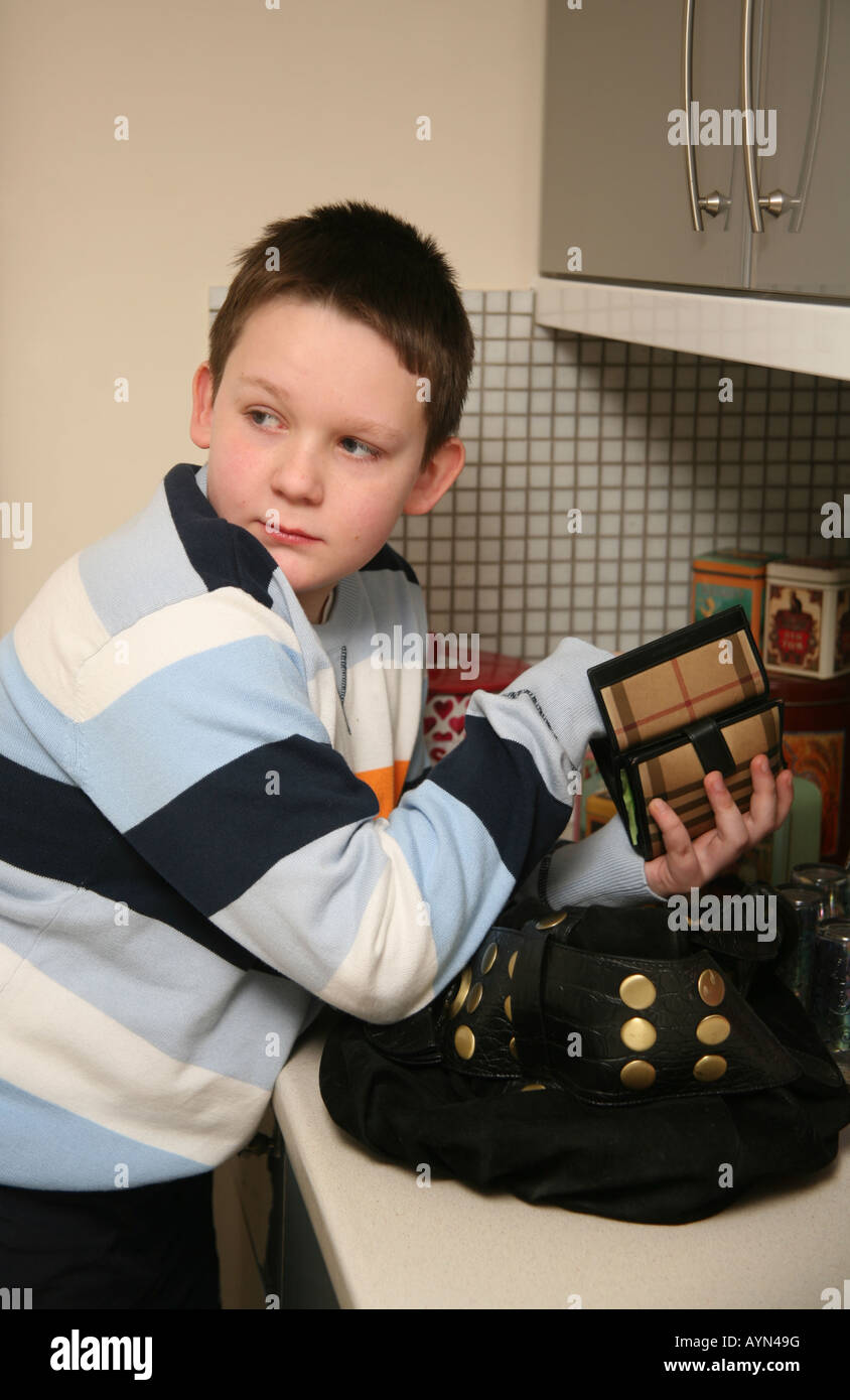 12 year old teenage boy stealing money from a purse Stock Photo