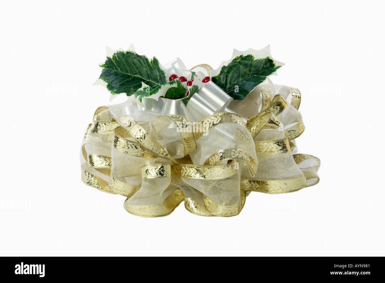 Fancy Christmas bow with holly leaves and berries for an elegant Christmas gift with white and gold satin ribbon, Silhouetted on a white background Stock Photo