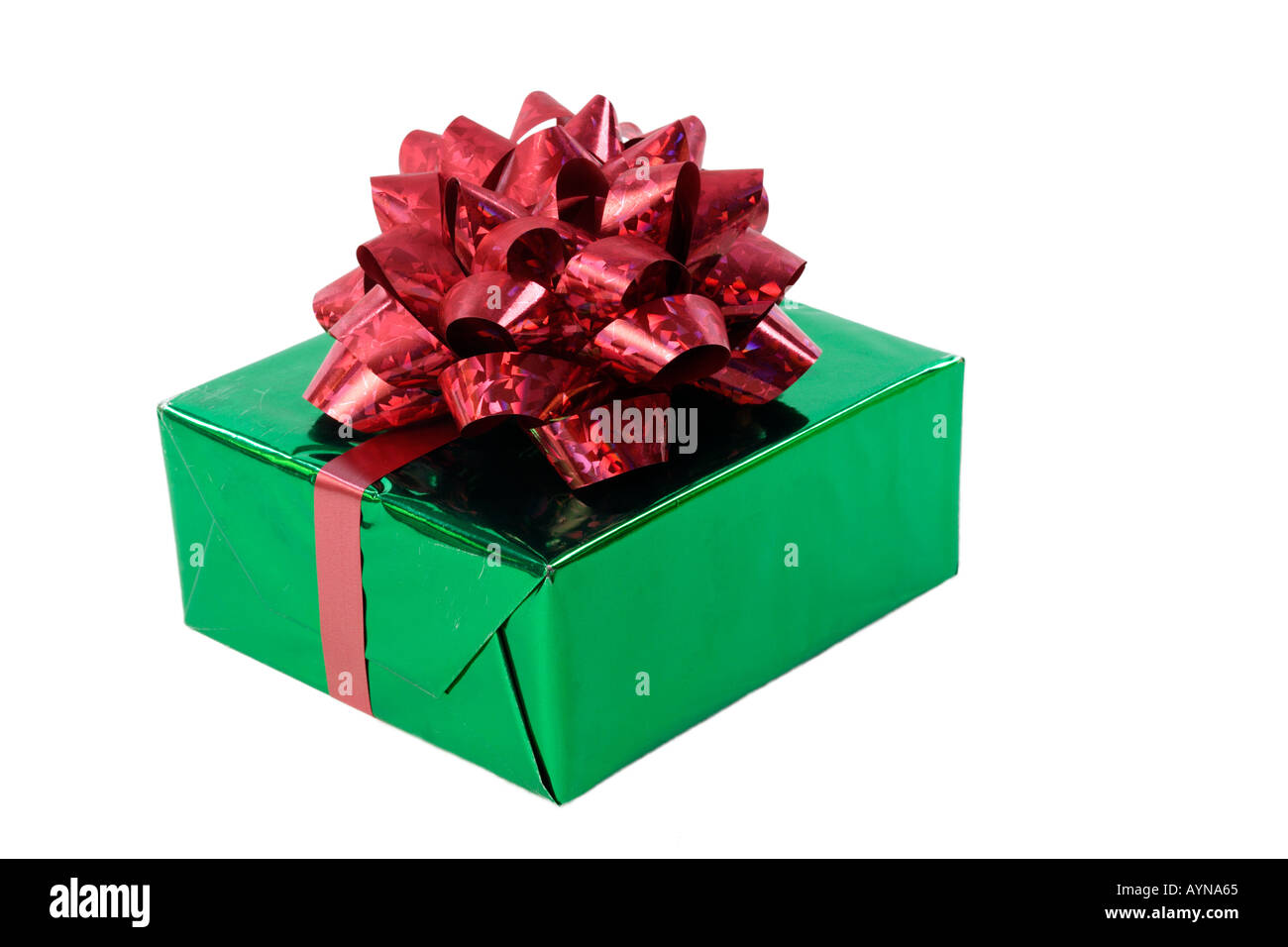 Still life of a shiny green gift wrapped present with an ornate red bow isolated on a white background Stock Photo