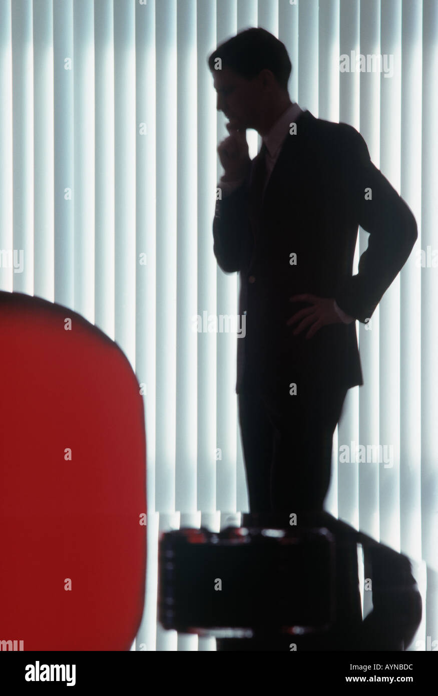 silhouette of an anonymous business executive deep in thought in his office Stock Photo