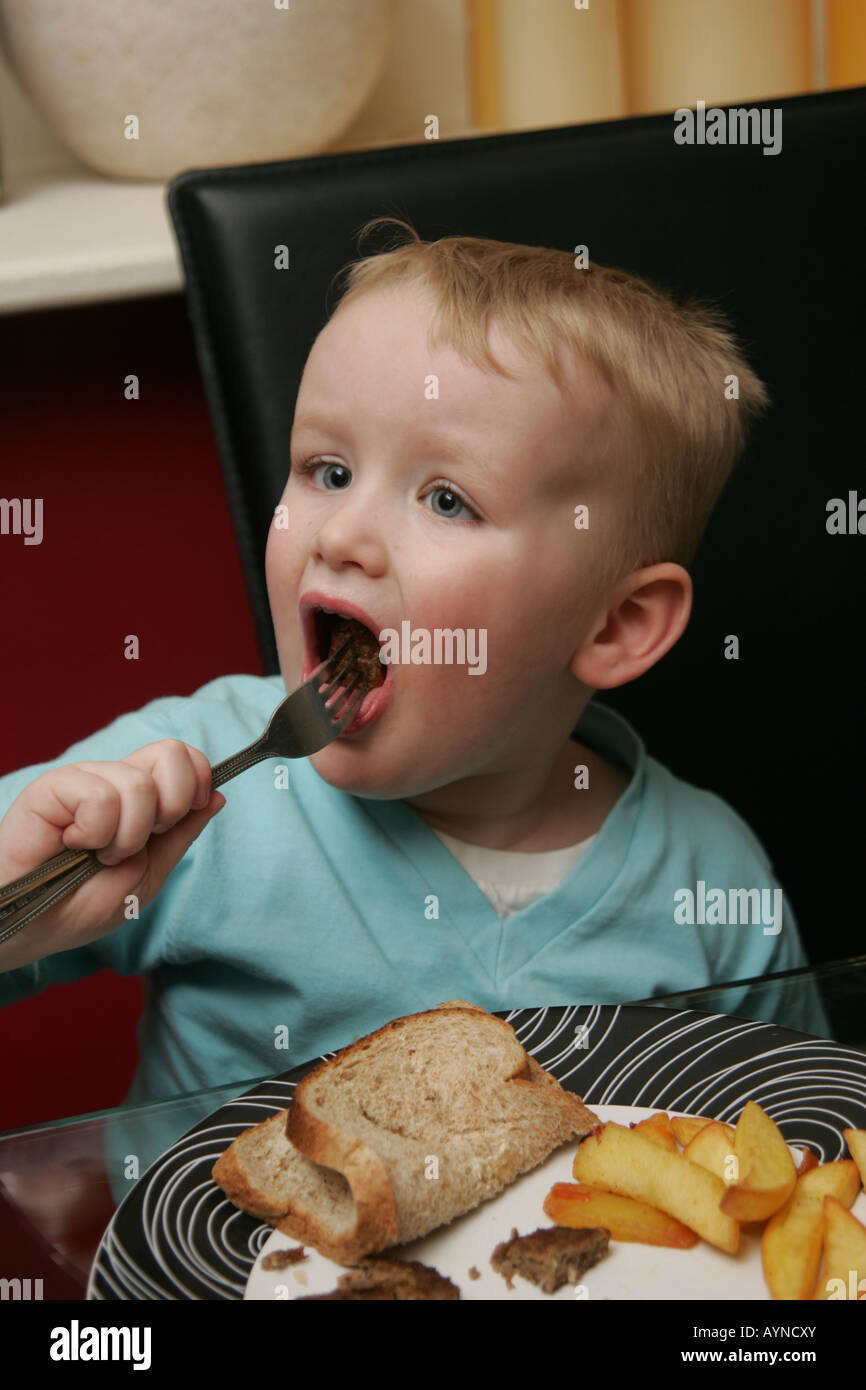 Toddler eating dinner Stock Photo Alamy