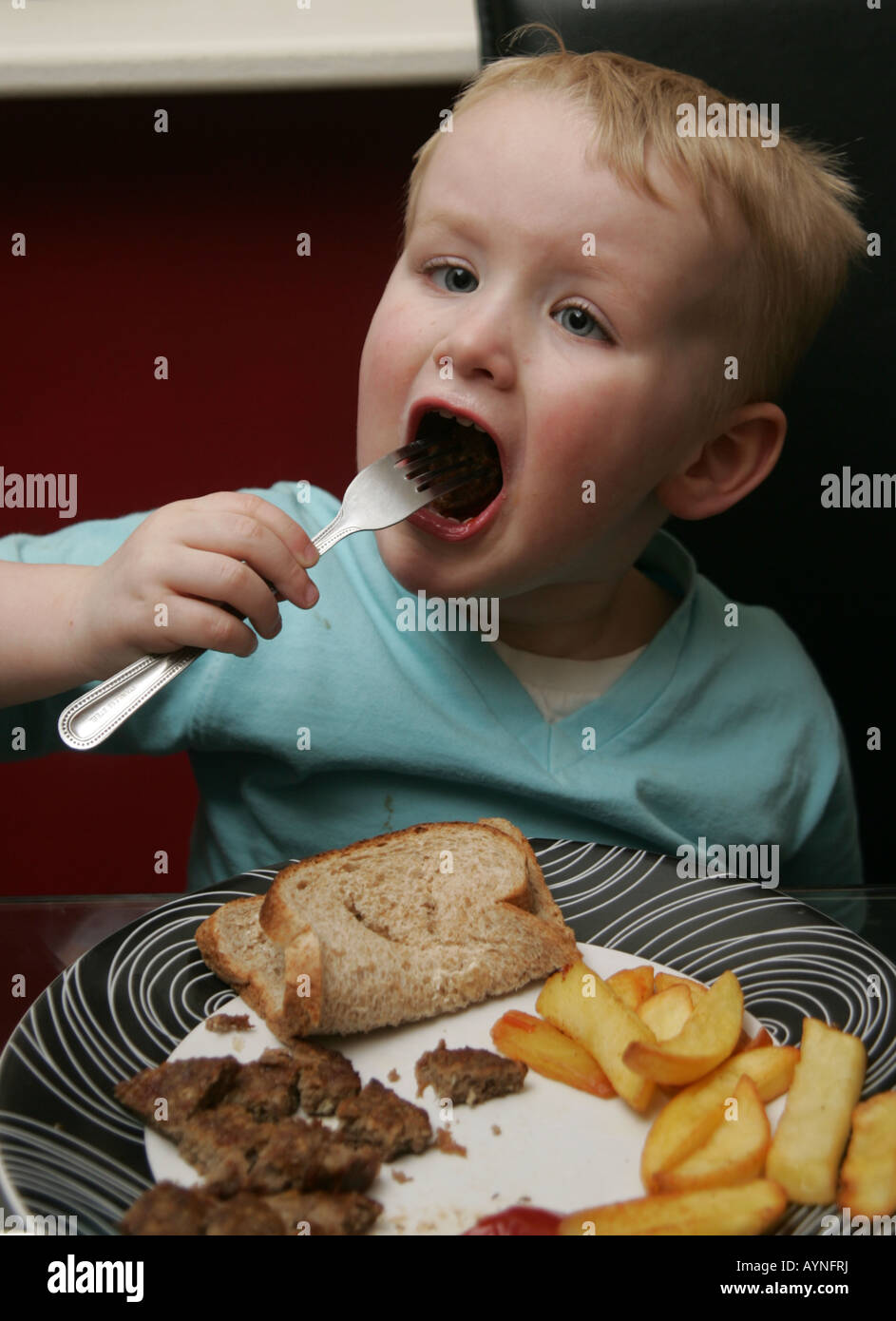 Toddler eating dinner Stock Photo - Alamy
