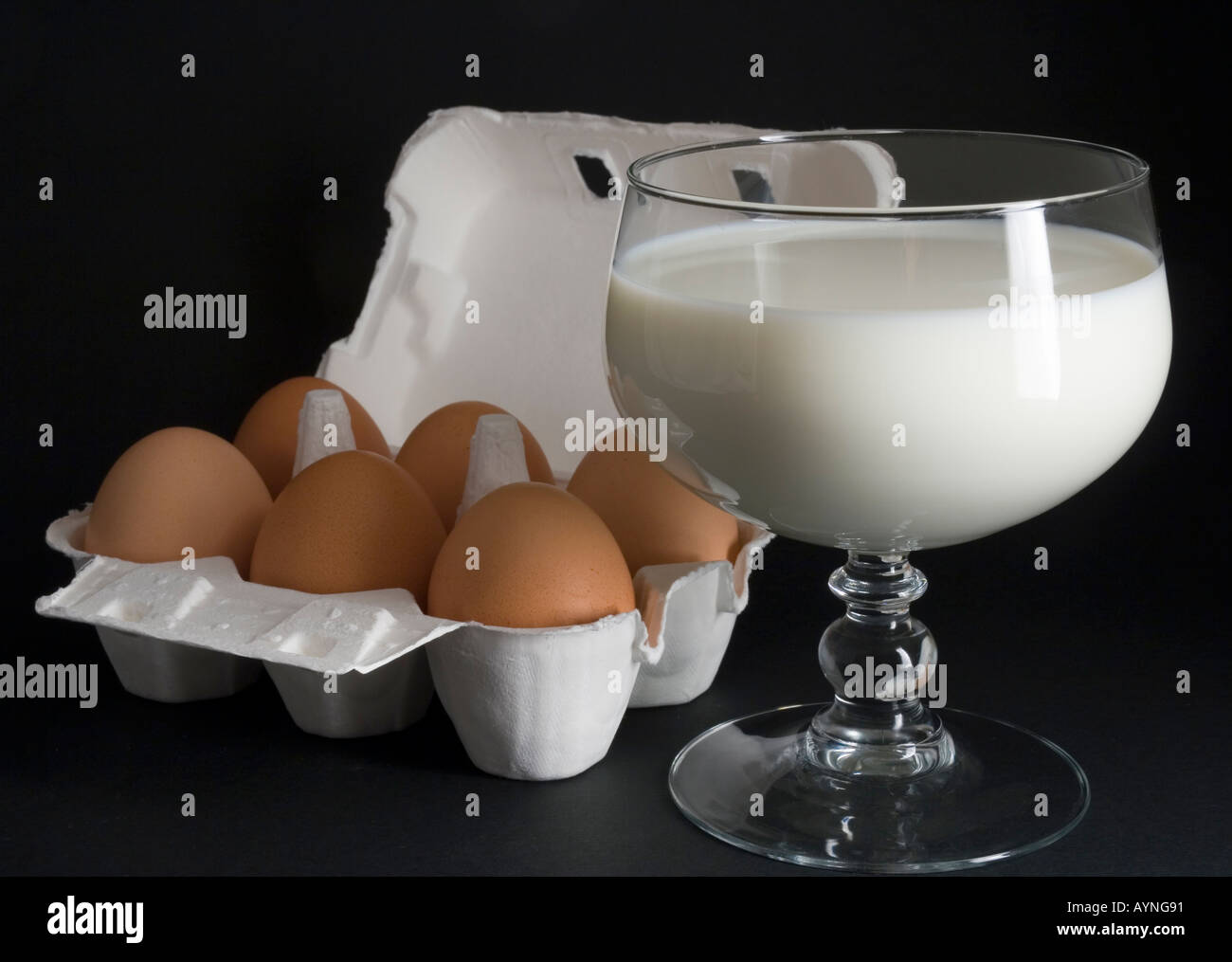 Six eggs in a box and a glass of milk on a black background Stock Photo ...