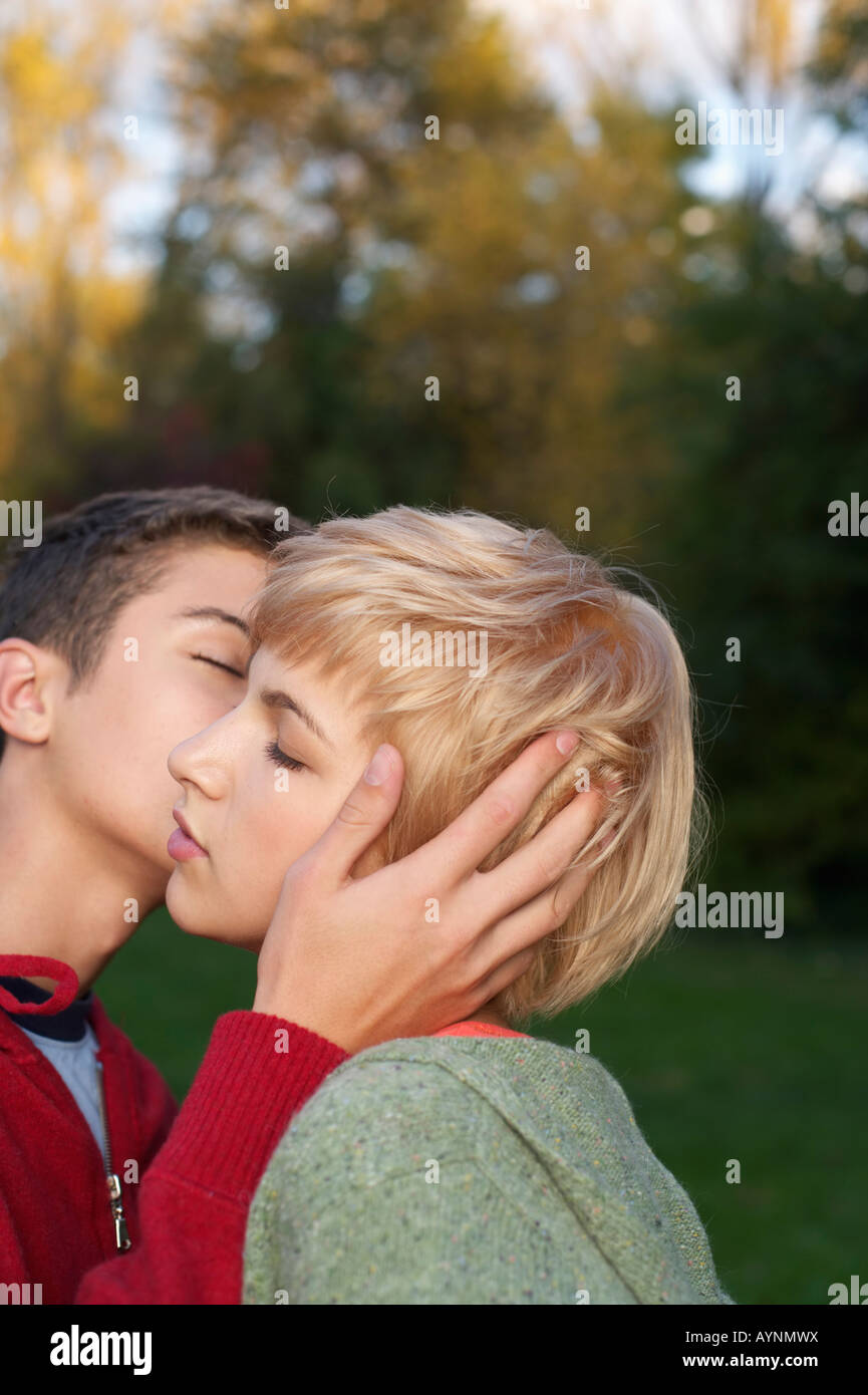 Teenage boy kissing a teenage girl on the cheek, close-up, selective focus  Stock Photo - Alamy