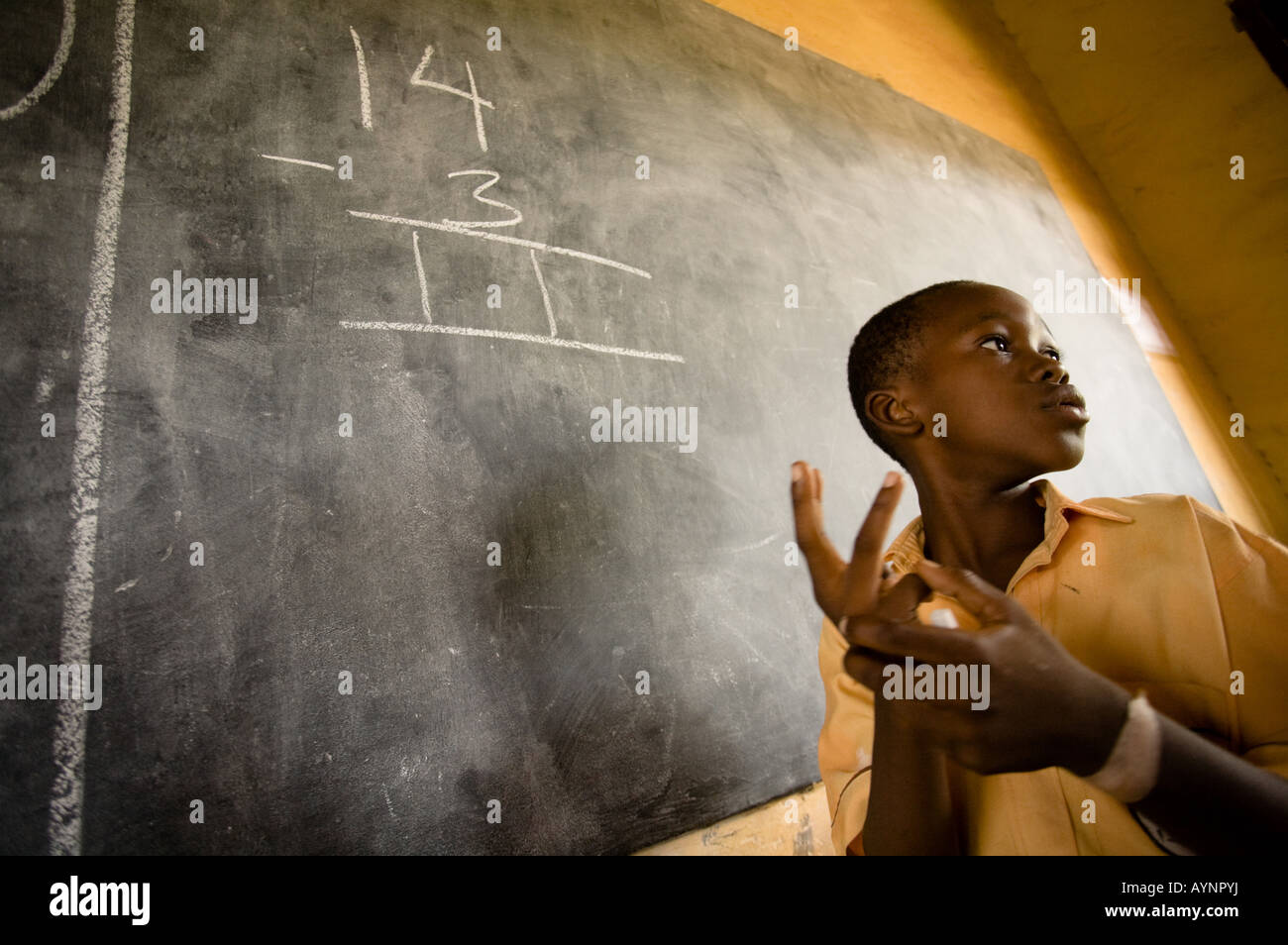A boy solves a math problem on the black board during class at the Dahin Sheli primary school in Tamale northern Ghana Stock Photo