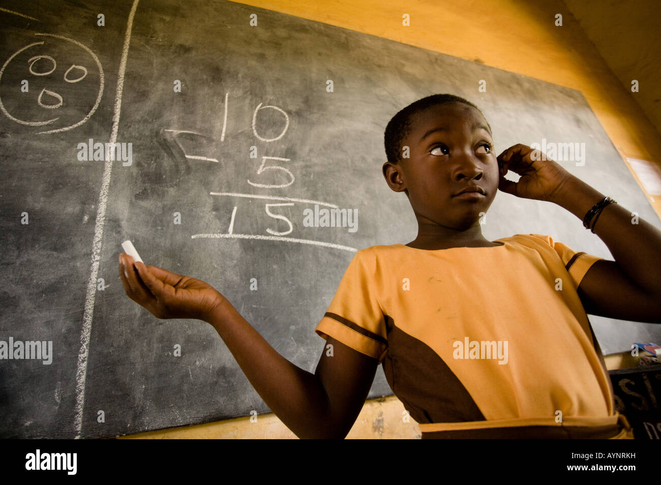 A girl attempts to solve a math problem on the black board during class at the Dahin Sheli primary school in Tamale northern Gha Stock Photo