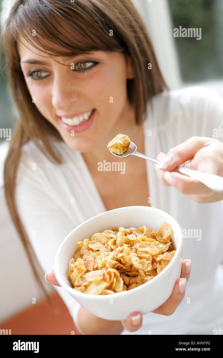 Brunette girl eating Cornflakes cereal Stock Photo
