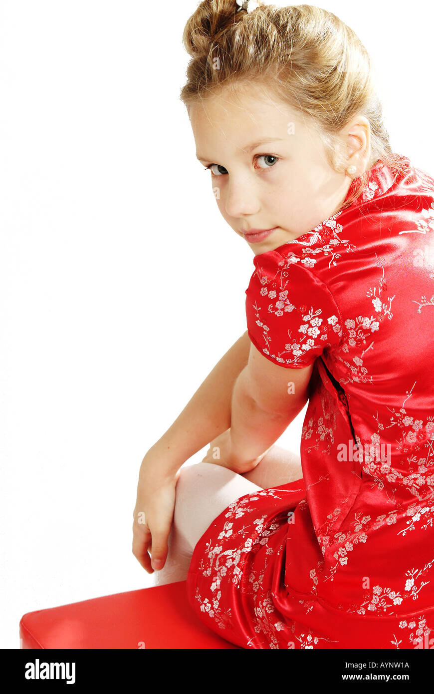 Zehnjaehriges Maedchen mit langen blonden Haaren und asiatischem Kleid Stock Photo
