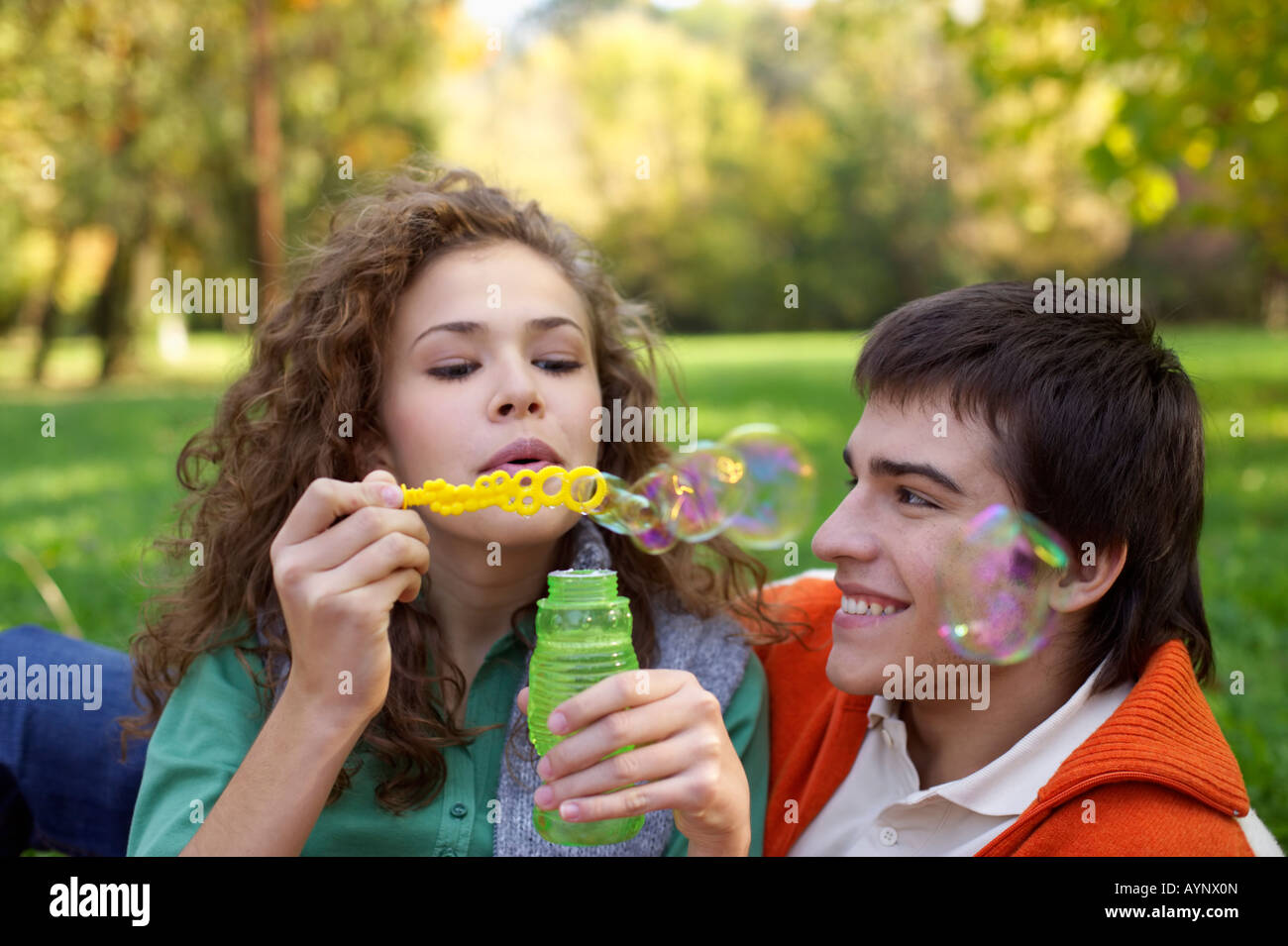 Teenage boy and girl making soap bubbles, close-up, selective focus Stock Photo