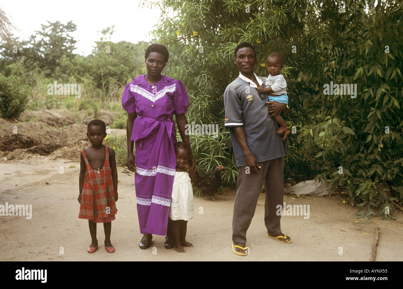 Family pose together for the camera in a typical village setting - Nkhotakota, Lake Malawi, Malawi Stock Photo