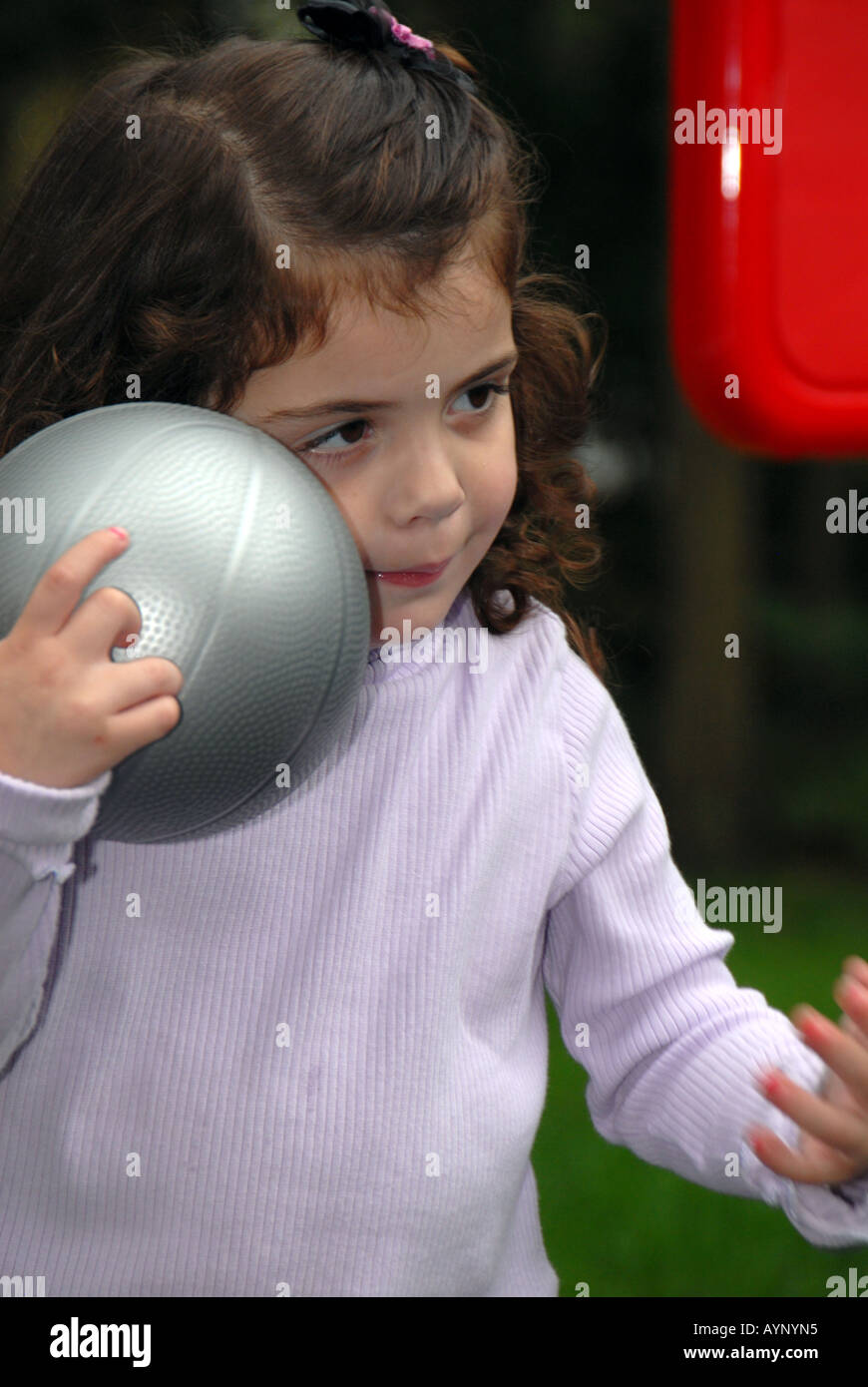 Three year old girl clutching a basketball Stock Photo Alamy