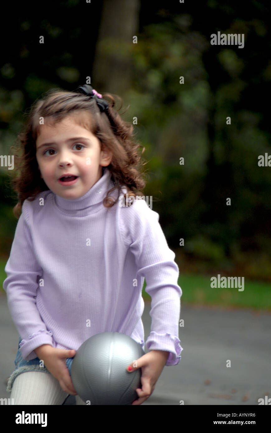 Three year old girl running and holding a basketball Stock Photo Alamy