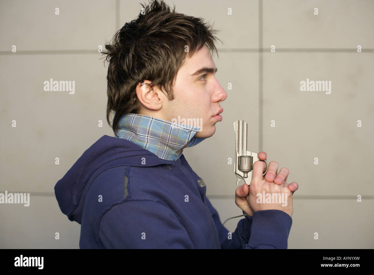 Young man holding a gun Stock Photo - Alamy