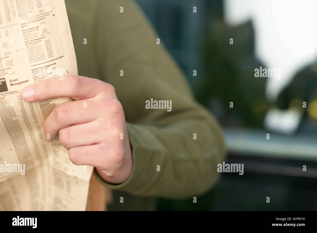 Young man reading a newspaper Stock Photo - Alamy