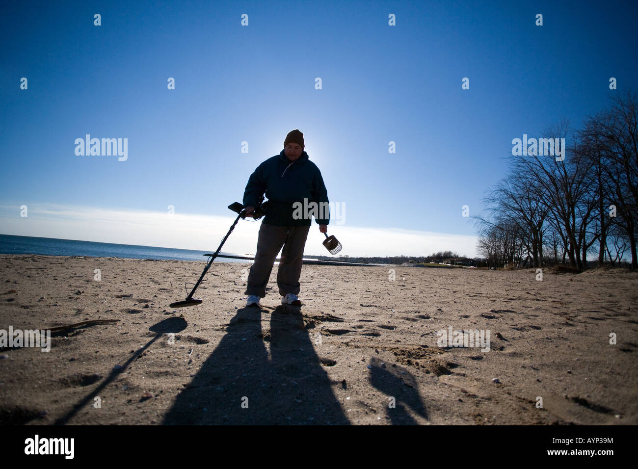 Man using a metal detector on a Beach in West Haven Connecticut USA