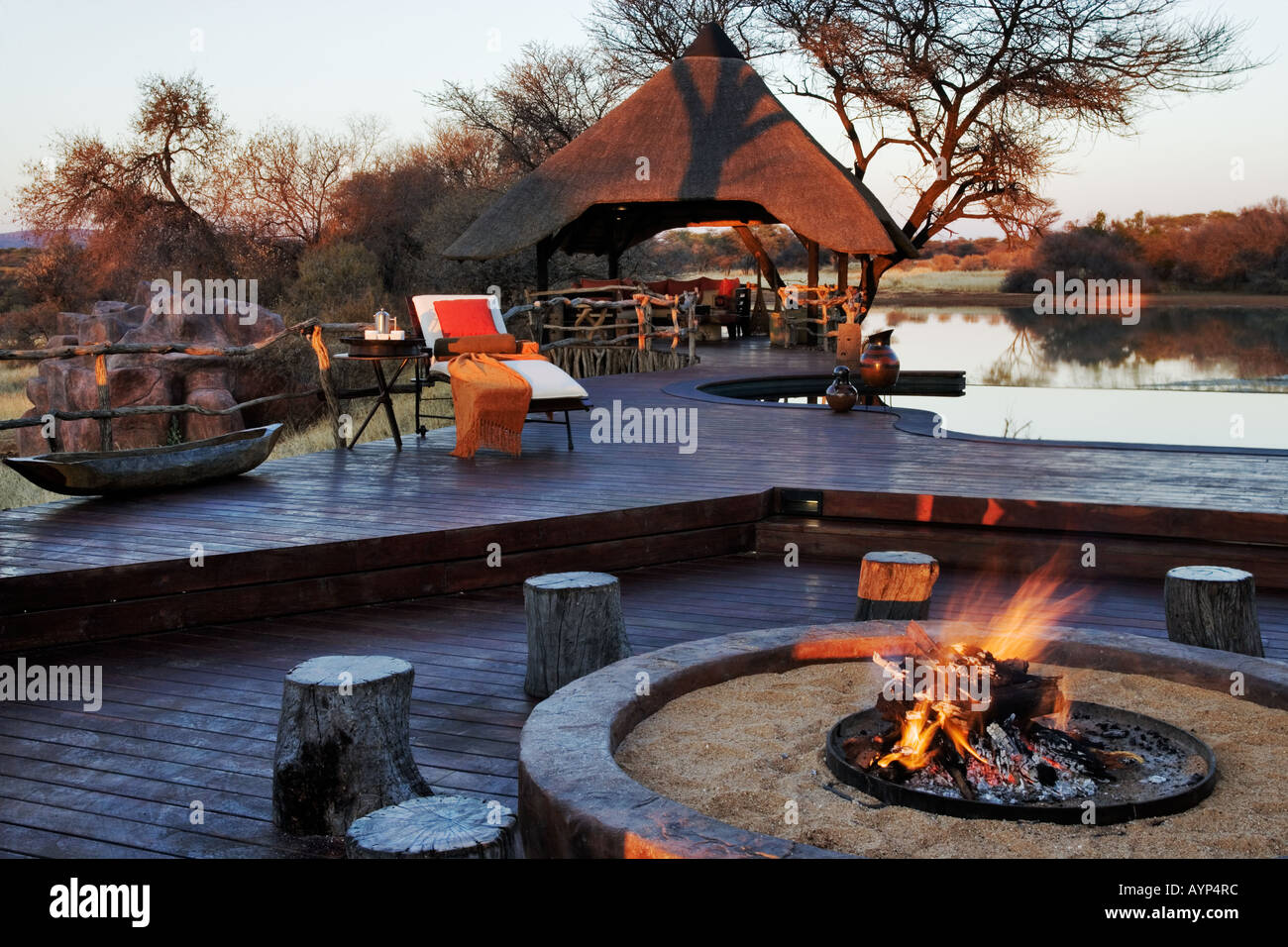 Around open fires are where guests at The Villa in Okonjima Private Game Reserve Namibia gathers to watch animals Stock Photo