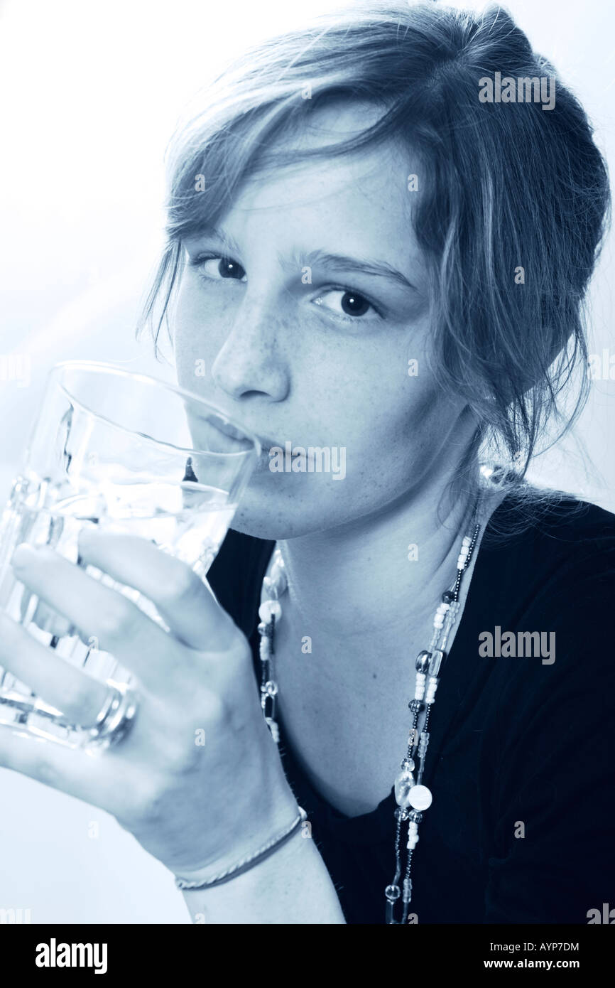Young woman drinking a glass of water blue tone Stock Photo Alamy