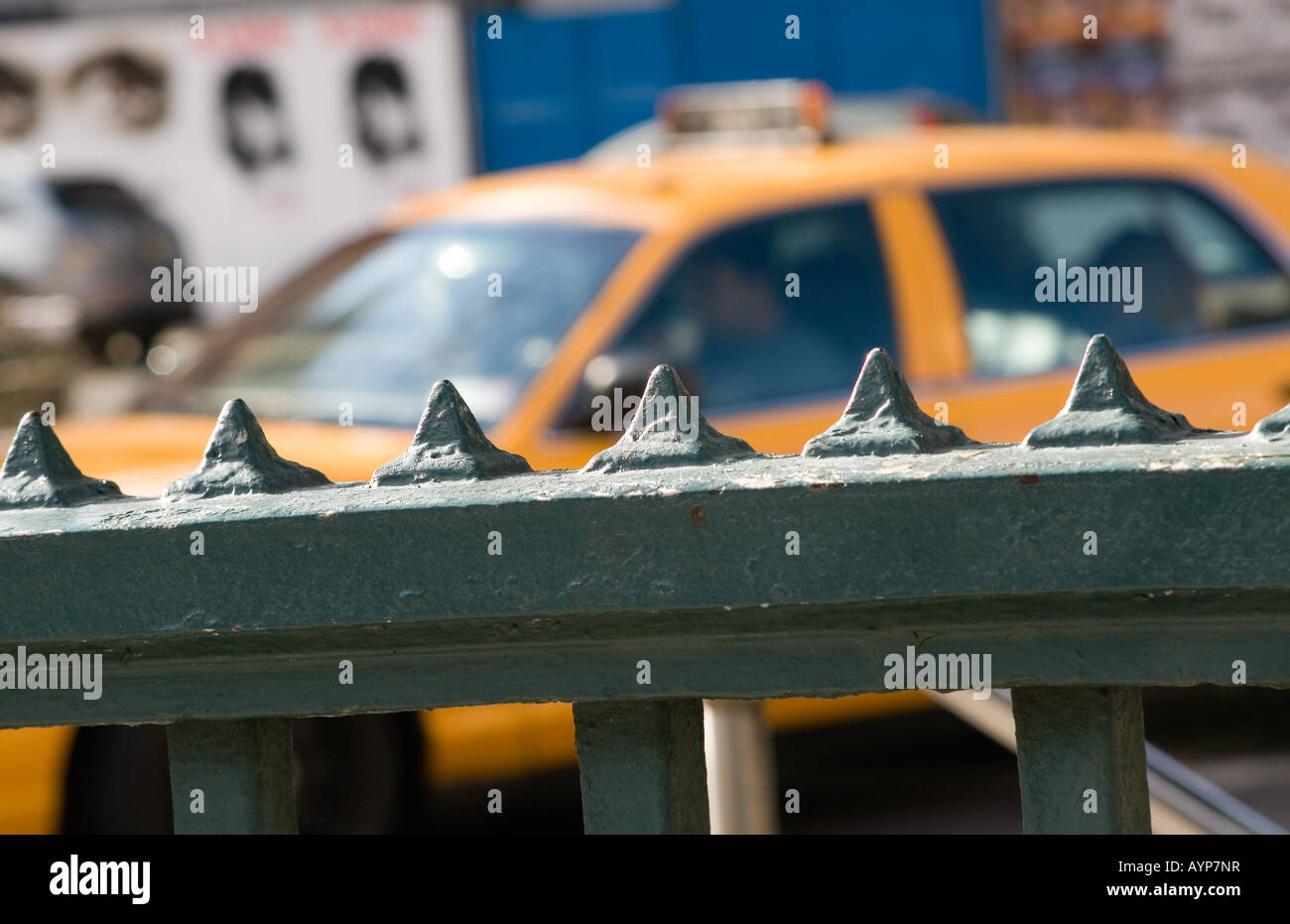 Spikes on subway railing with Yellow Cab in background Stock Photo - Alamy