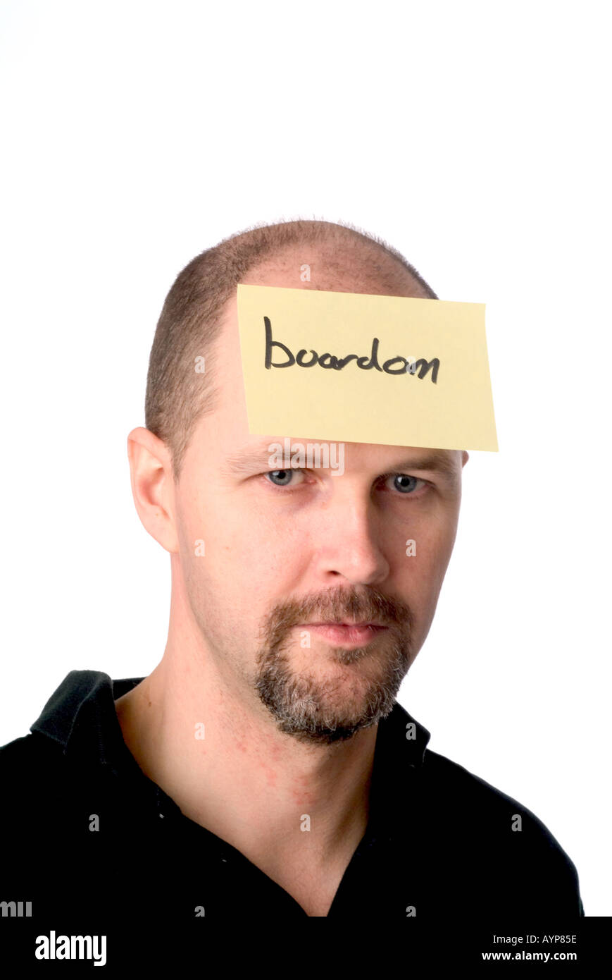 man with a post it note on his head representing that he is bored boring laborious boredom facial expression meeting Stock Photo