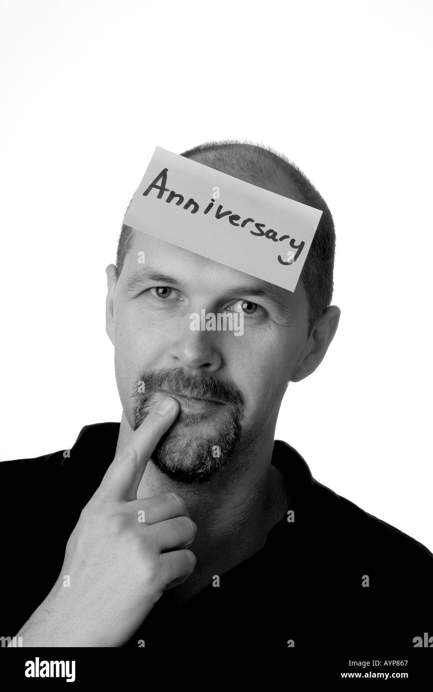 man with post it note on head representing that he must remember his wedding anniversary anniversary memory good bad forgotten f Stock Photo
