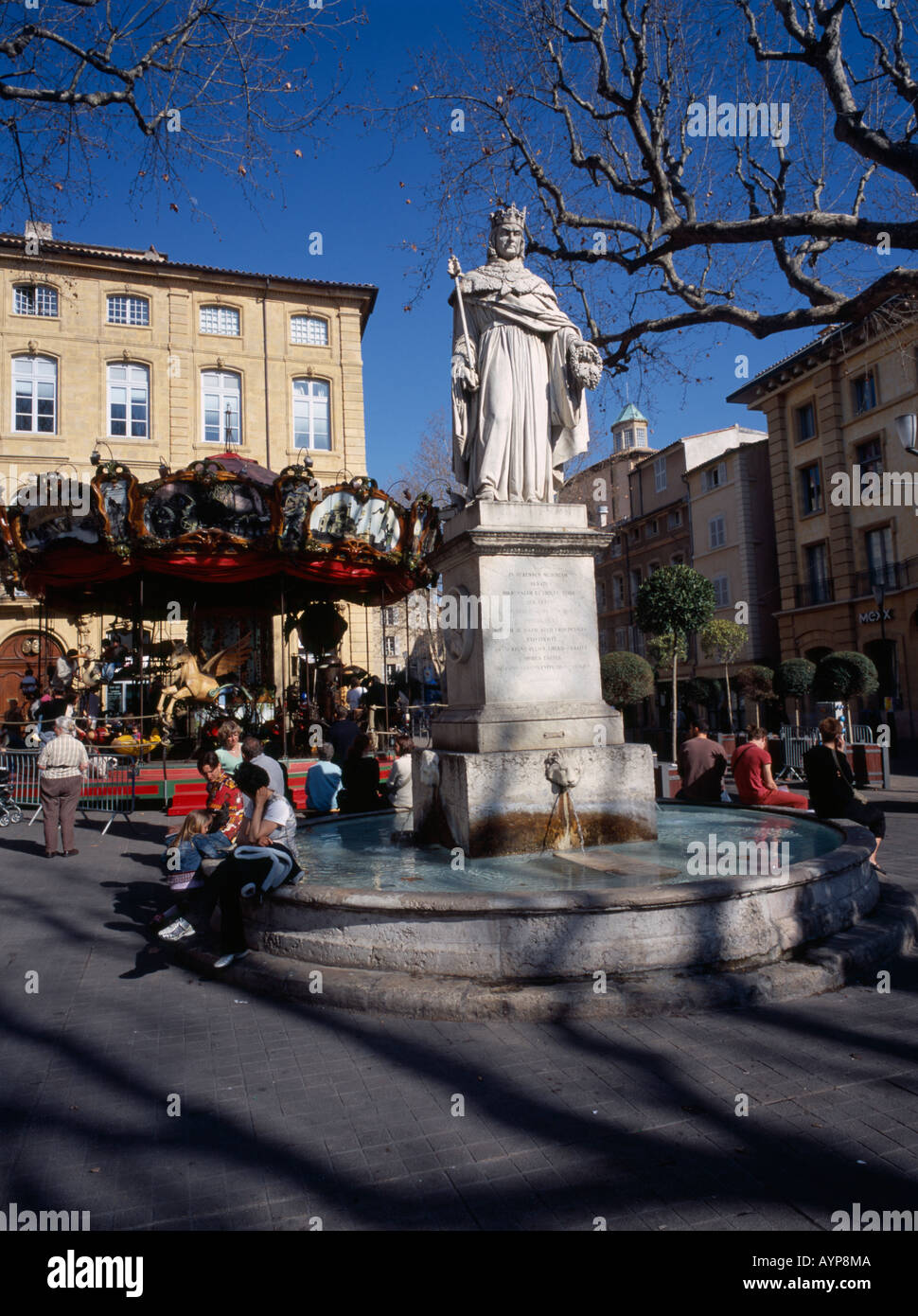 FRANCE Aix en Provence Statue of King René in Cours Mirabeau with people  sat on edge of fountain with Carousel ride behind Stock Photo - Alamy