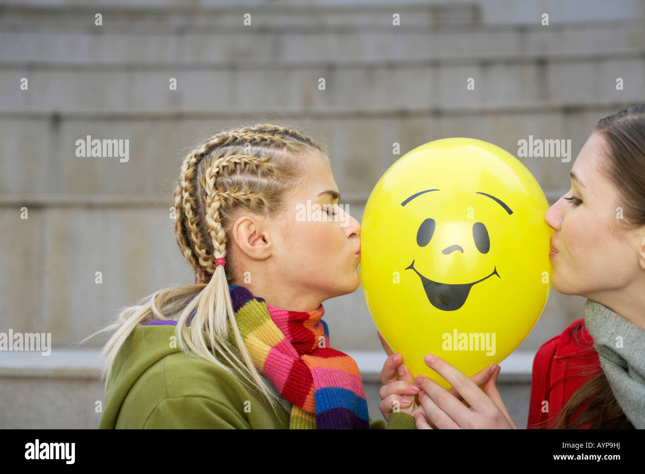 Two young women kissing balloon Stock Photo Alamy