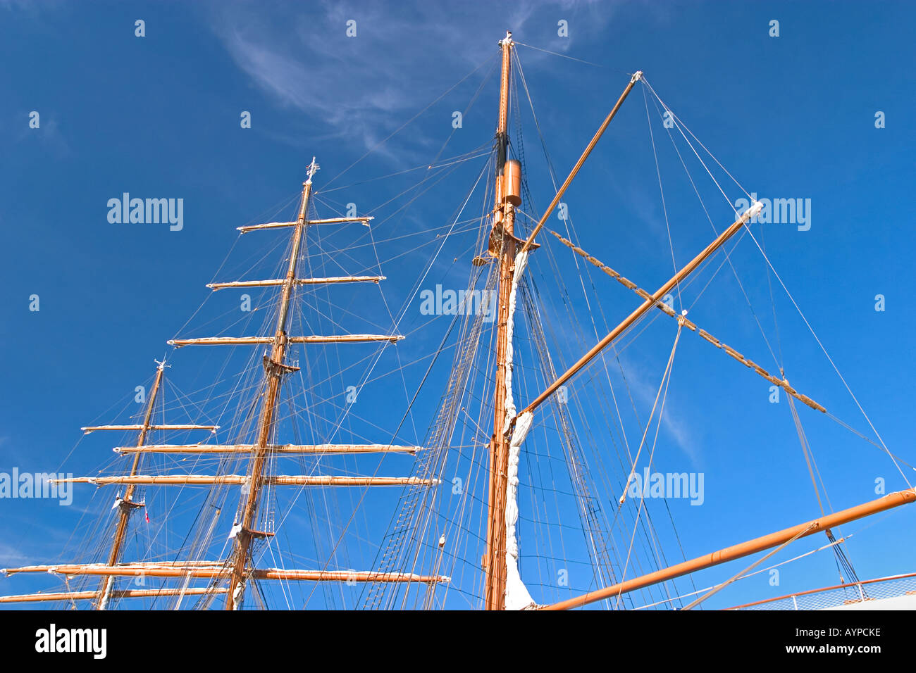 Tall ship sail masts against a blue sky Three masted large schooner ...