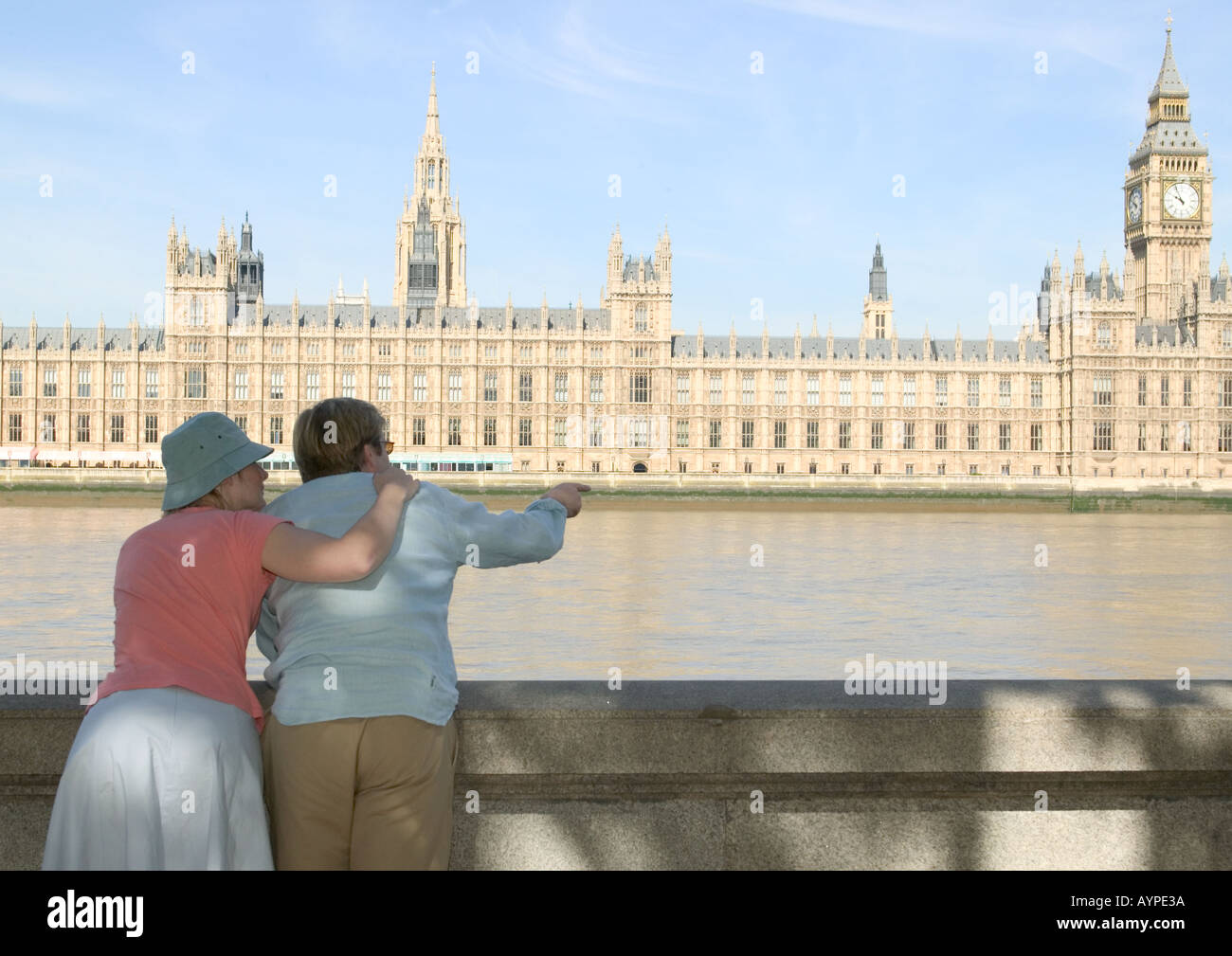 couple standing backs turned looking at house of parliament london Stock Photo