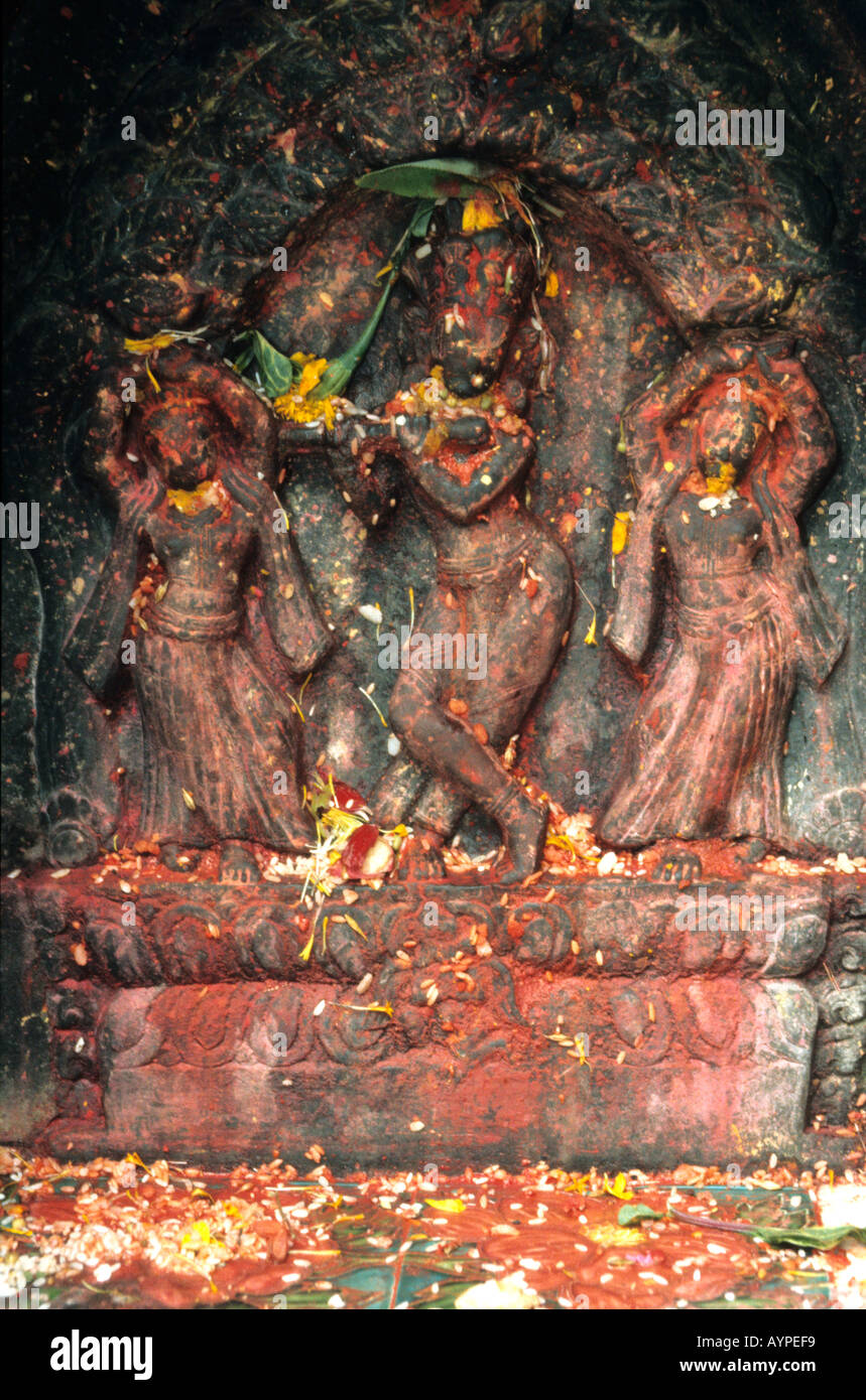 Intricate stone sculpture of Hindu gods covered in red powder and ...