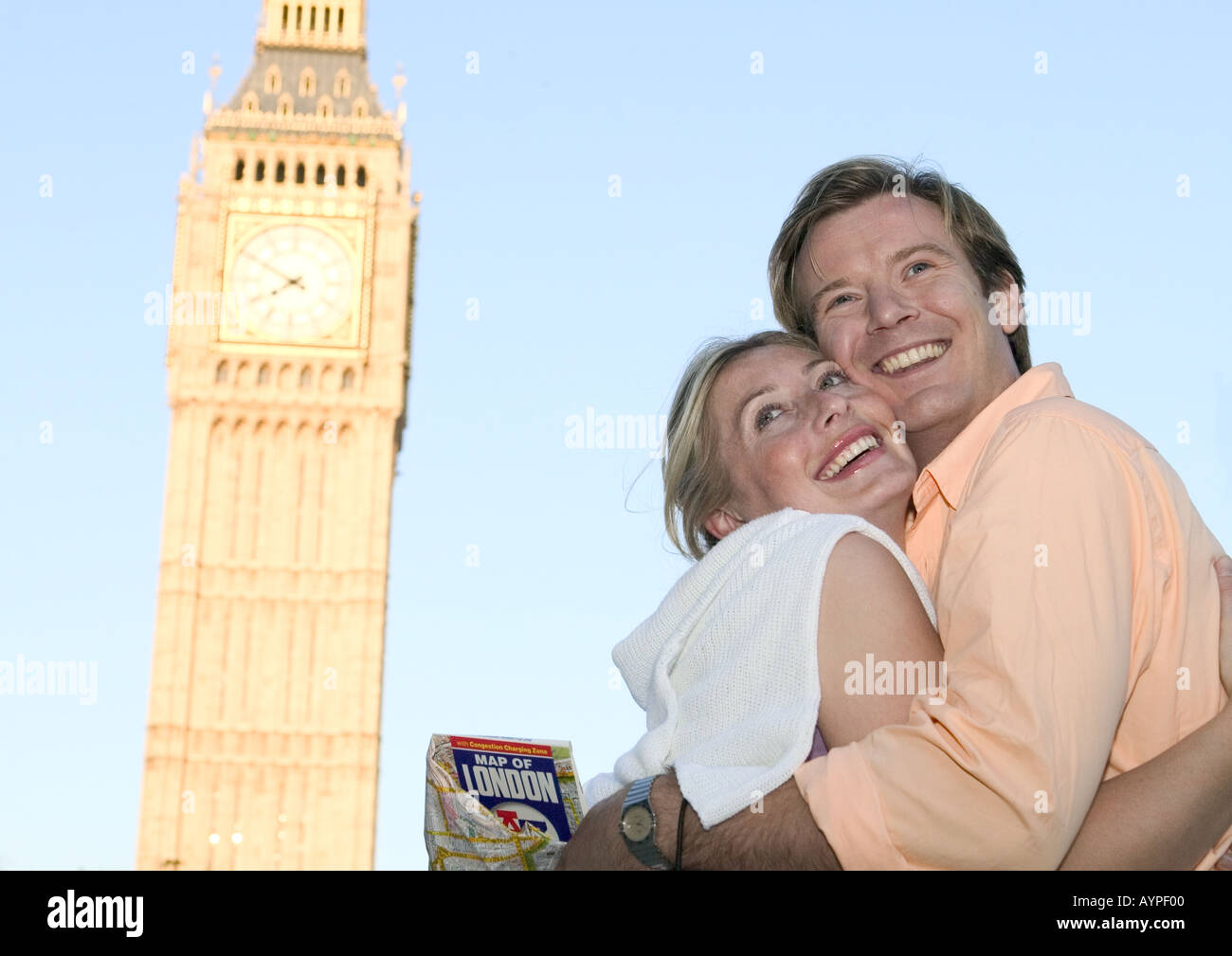 couple embracing and smiling opposite big ben lodon Stock Photo