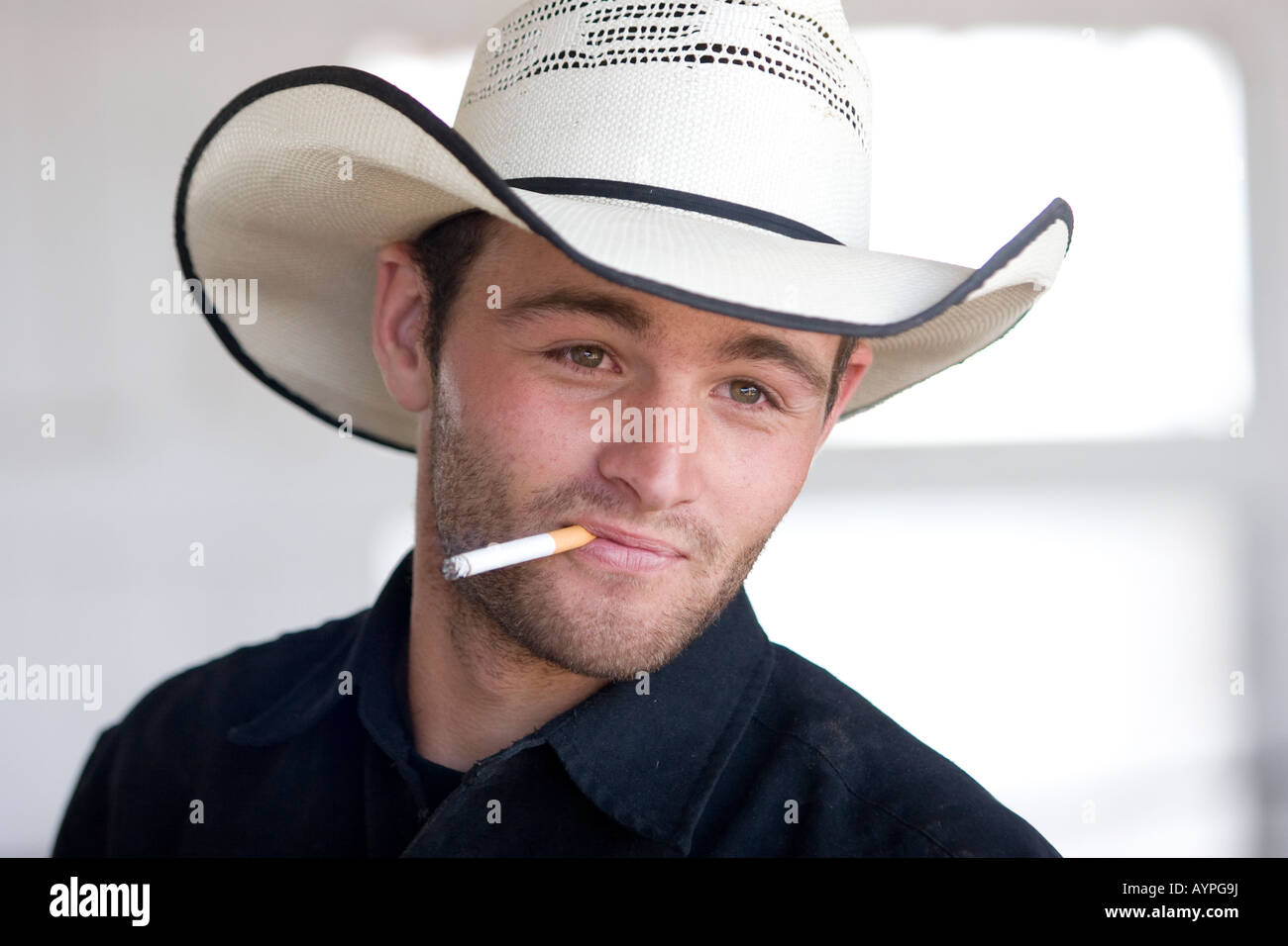 A working cowboy on a ranch in colorado in a hat and smoking a cigarette Stock Photo