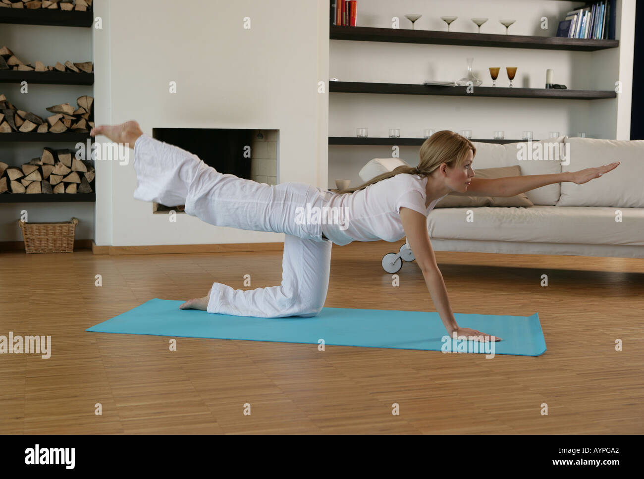 A blonde woman performing an exercise on the floor Stock Photo
