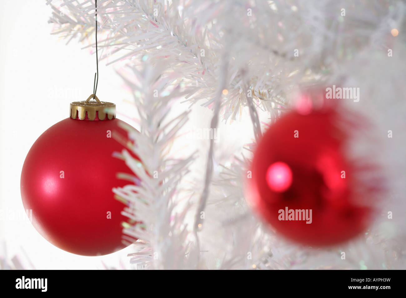 Two red Christmas tree balls on a white Christmas tree Stock Photo - Alamy