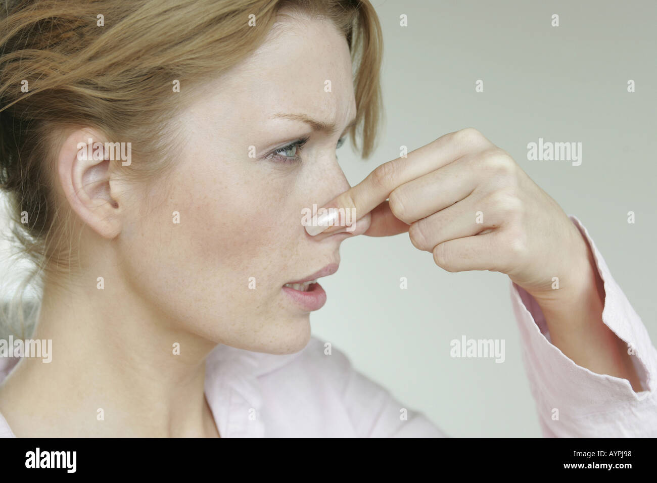 A woman closes her nose as something stinks near her Stock Photo