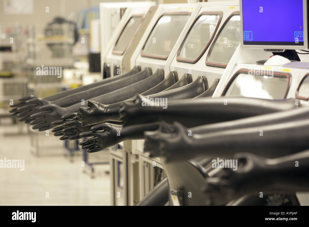 Arm length pressurized black gloves sticking out from a glove box in a