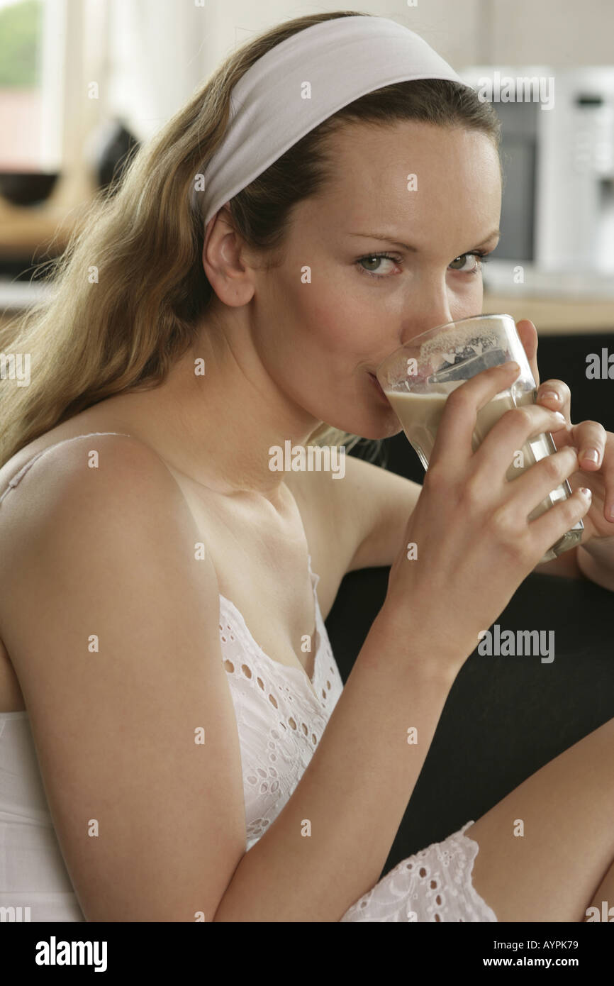 A side view of blonde woman having a glass of coffee Stock Photo