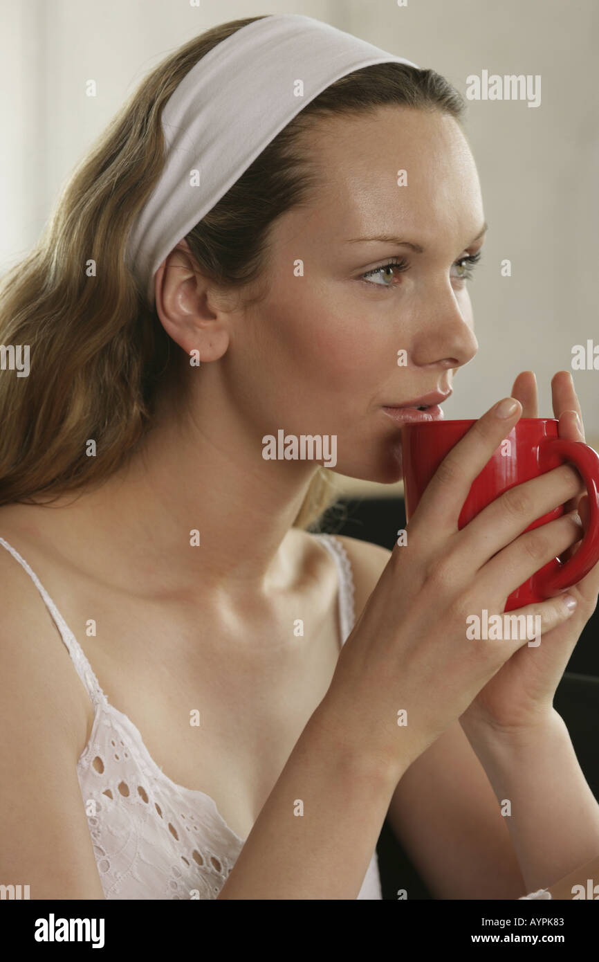 A blonde woman in slip having a cup of coffee Stock Photo