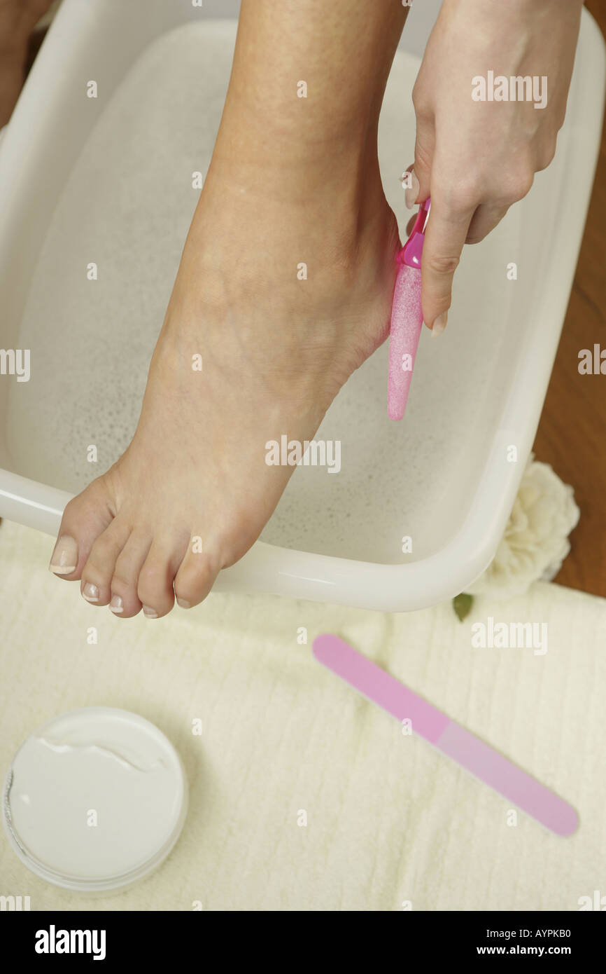 A high angle view of the leg of a woman above a soapy tub Stock Photo