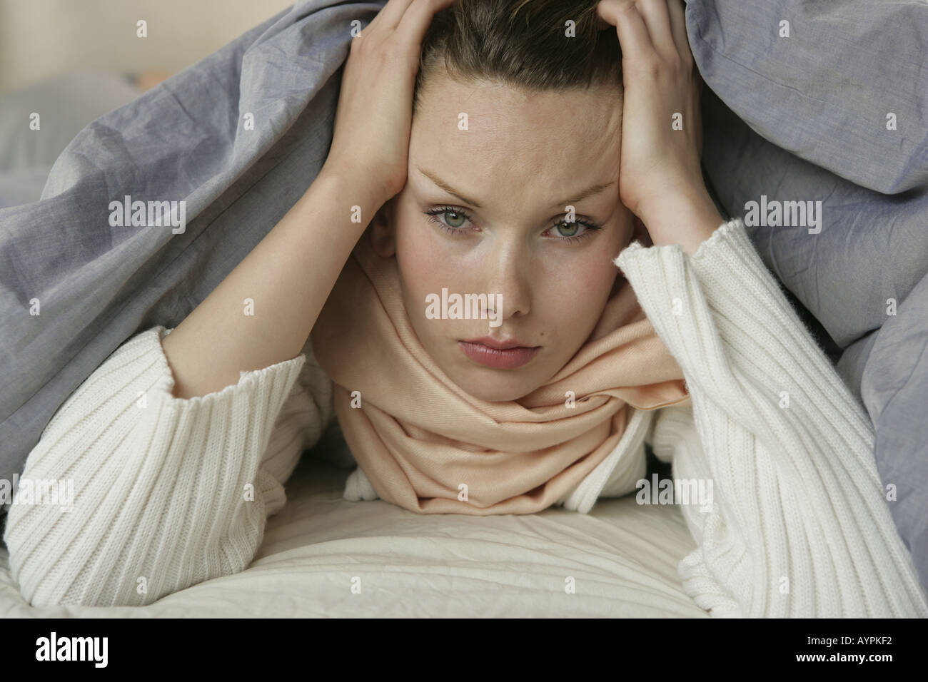 A young woman hiding herself under a blanket Stock Photo