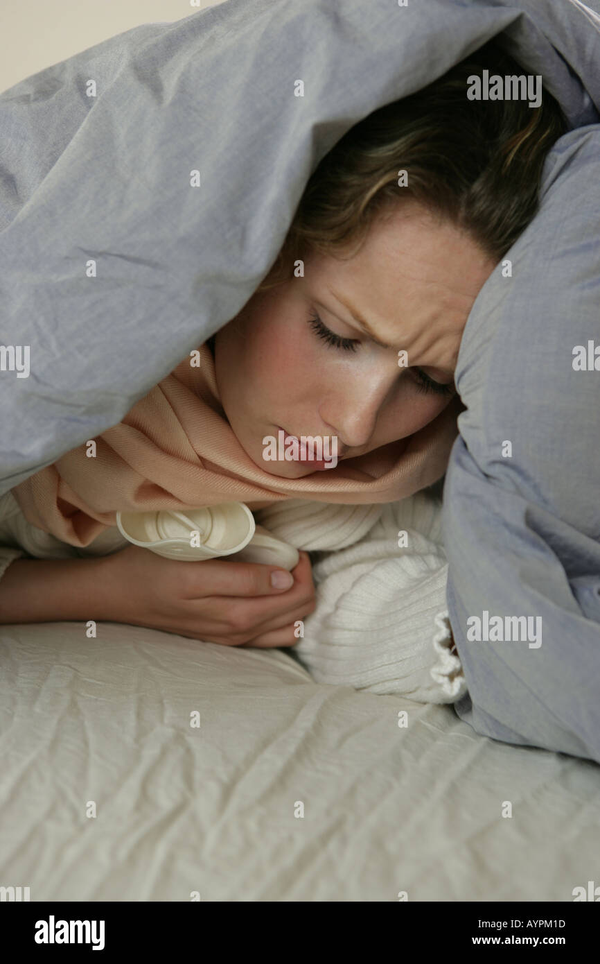 A woman hidden in her blanket due to cold and pain Stock Photo