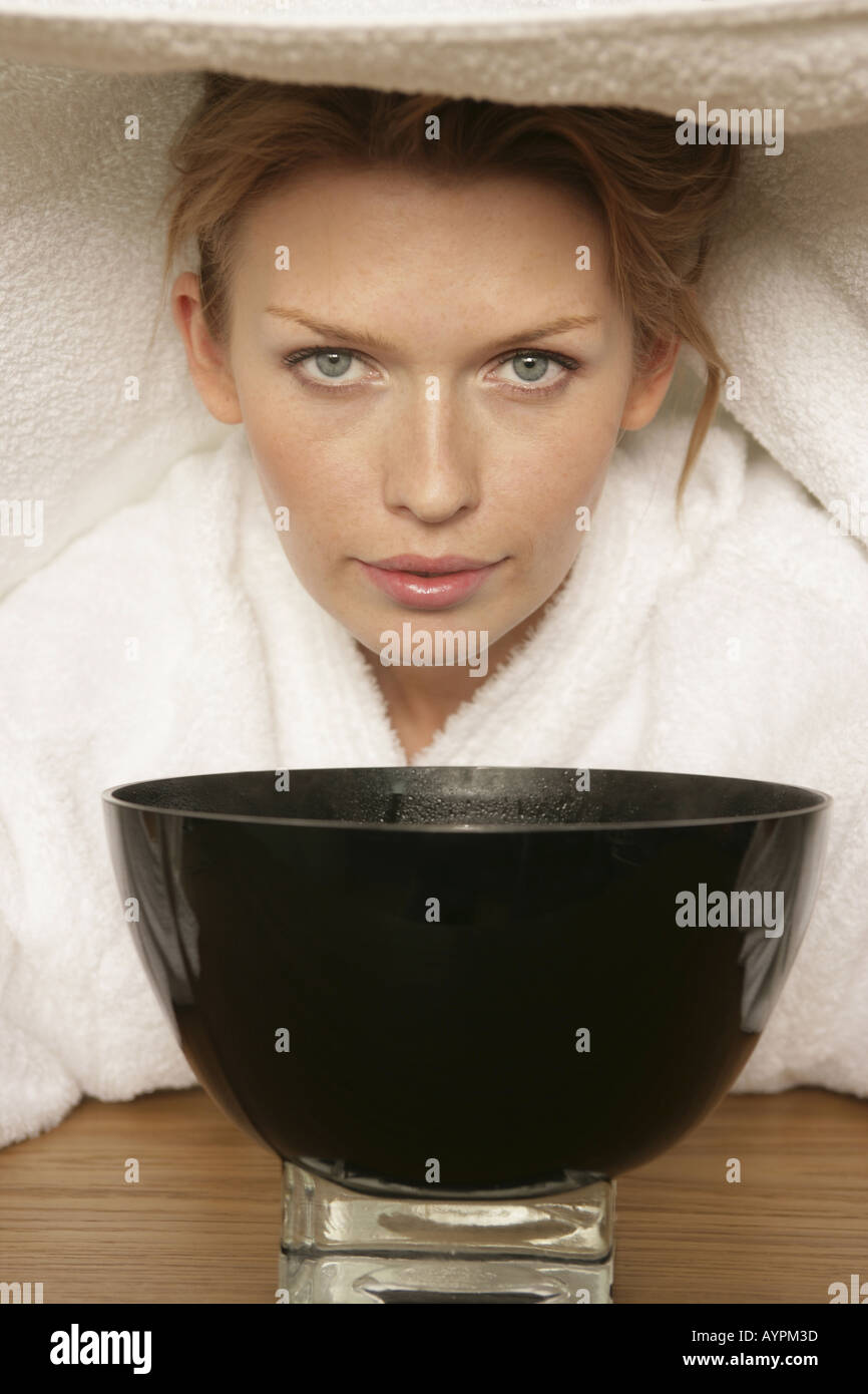 A woman taking steam from a bowl Stock Photo