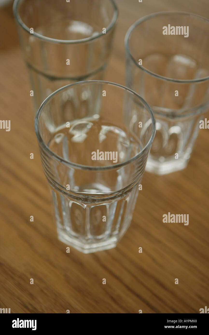 Three empty glasses kept on a table Stock Photo