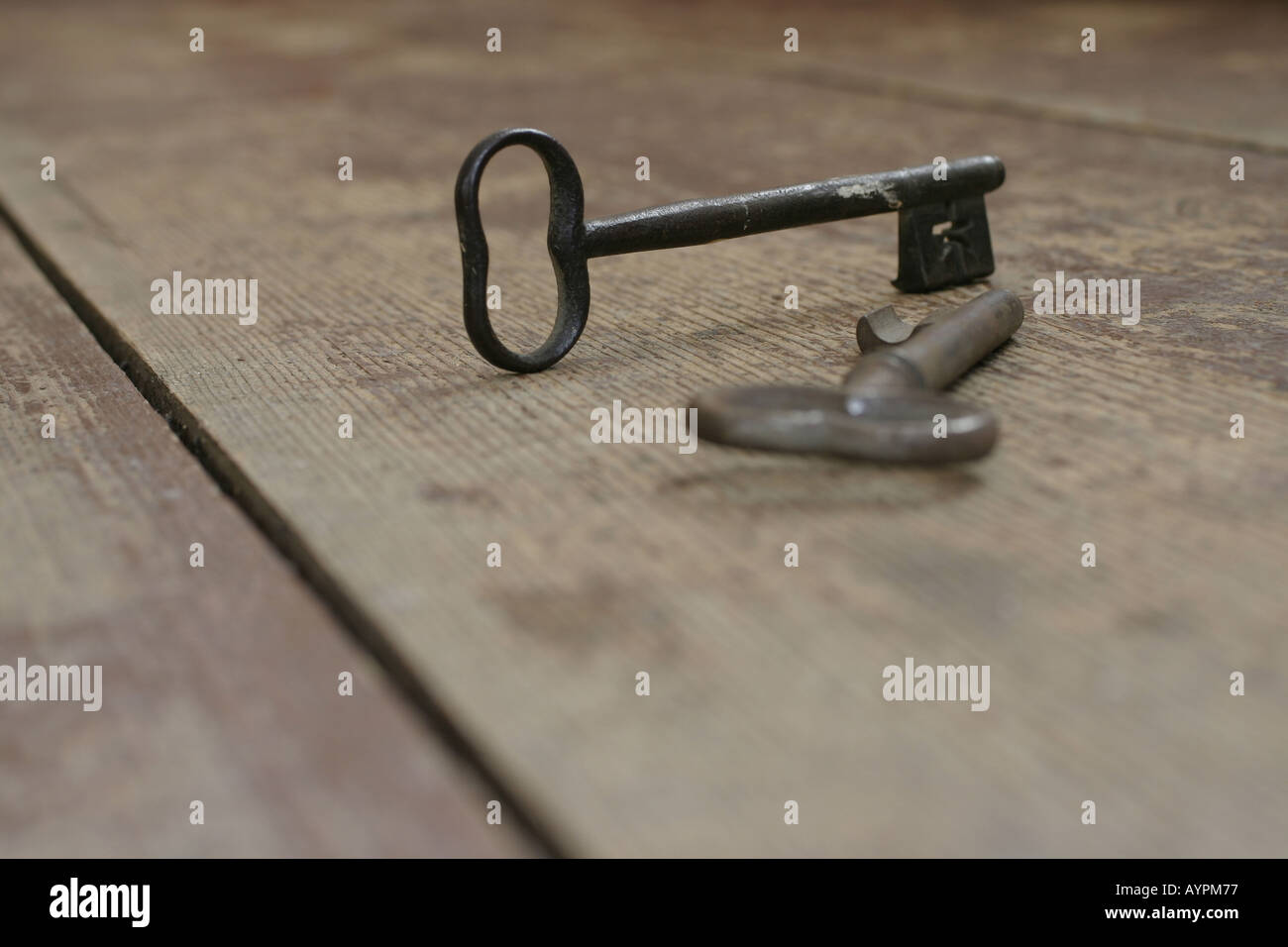 Two antique keys placed on a wooden table Stock Photo