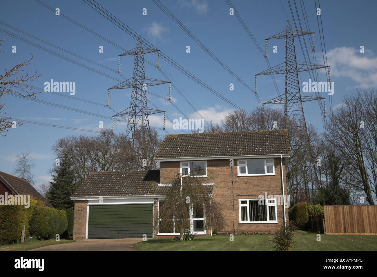 Electricity power lines passing over suburban houses Aldringham near Leiston Suffolk England Stock Photo