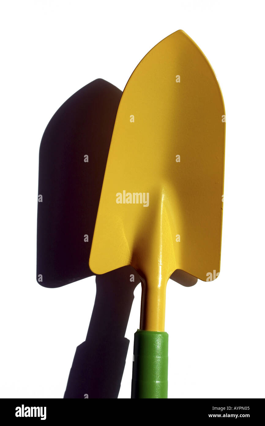 A yellow colored shovel is placed against the white background Stock